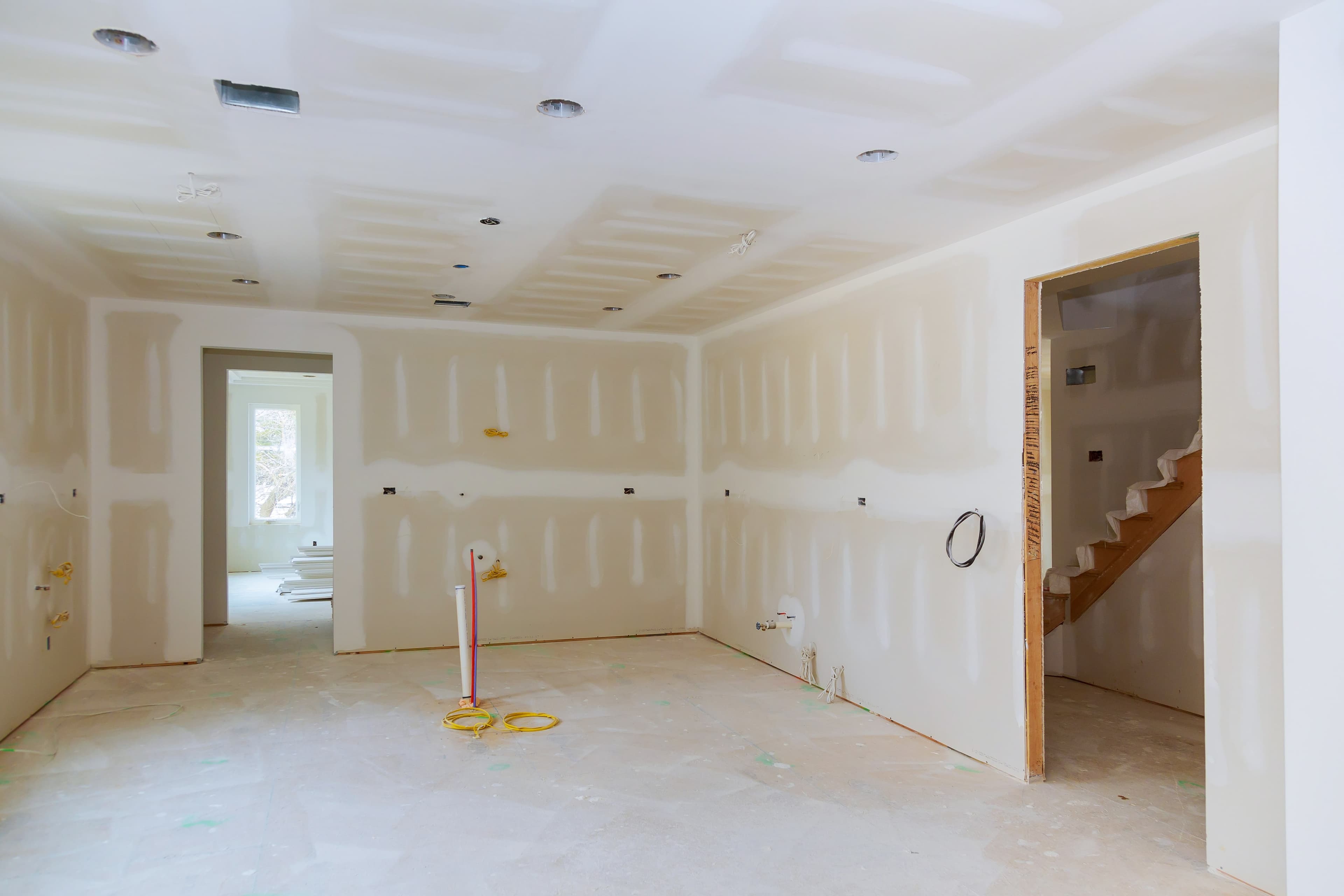 Finished drywall installation and taped seams in a renovation space before painting